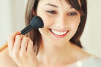 Wanita memakai blush on.